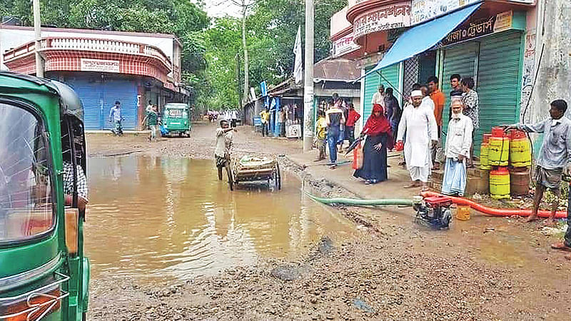 গর্তের পানি নিষ্কাশন করা হচ্ছে। মঙ্গলবার সকালে বড়লেখার দাসেরবাজার এলাকায়। প্রথম আলো