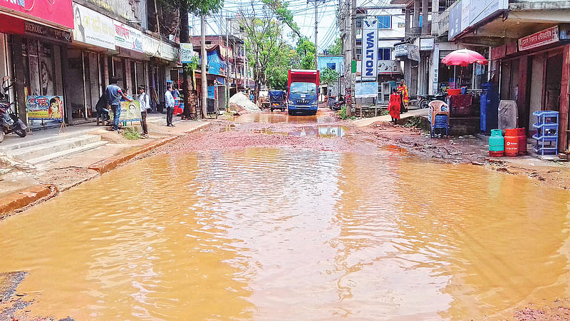 সখীপুর-গারো বাজার সড়কের খাদ্যগুদাম এলাকায় গর্তে পানি জমে বেহাল অবস্থার সৃষ্টি হয়েছে। গত বুধবার দুপুরে তোলা।  ছবি: প্রথম আলো