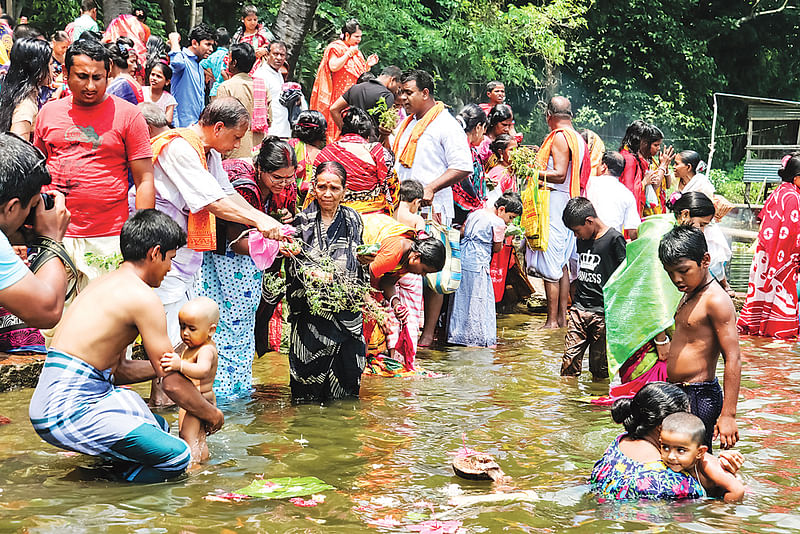 ঐতিহ্যবাহী দুর্গাসাগর দীঘিতে পুণ্যস্নান করতে ভক্তদের ভিড়। গতকাল সকালে বাবুগঞ্জের মাধবপাশা ইউনিয়নে।  ছবি: প্রথম আলো