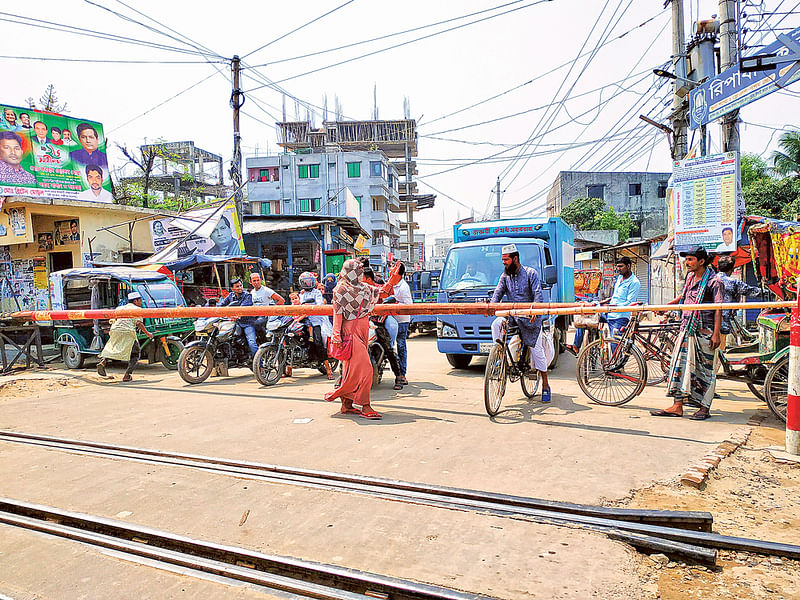 টঙ্গীর বনমালা লেভেল ক্রসিংয়ে দায়িত্ব পালন করছেন এক নারী। সাম্প্রতিক ছবি।  প্রথম আলো