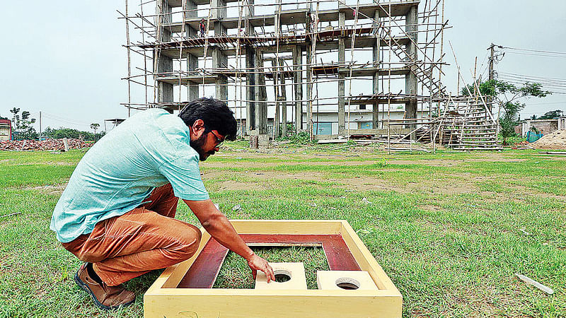 শহীদ মিনারে মা বর্ণমালা স্থাপনের কাজ করছেন স্থপতি রাজন দাস। সিলেটের লিডিং ইউনিভার্সিটি ক্যাম্পাসে গত বৃহস্পতিবার দুপুরে।  ছবি: প্রথম আলো