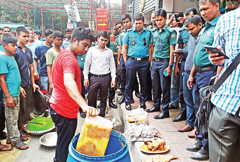 ধানসিঁড়ি রেস্টুরেন্টে অভিযান চালিয়ে উদ্ধার করা পচা–বাসি মাছ–মাংস ফেলা হচ্ছে ডাস্টবিনে। গতকাল দুপুরে  গুলশান–২ এলাকায়। ছবি: প্রথম আলো