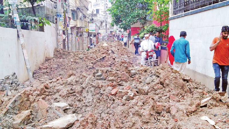 মালিবাগে আবুজর গিফারি কলেজের সামনের গলির রাস্তা কেটে পয়োনিষ্কাশনের লাইন বসাচ্ছে ডিএসসিসি। রাস্তা কাটা থাকায় চলাচলে ভোগান্তি হচ্ছে বলেন বাসিন্দারা।  ছবি: প্রথম আলো