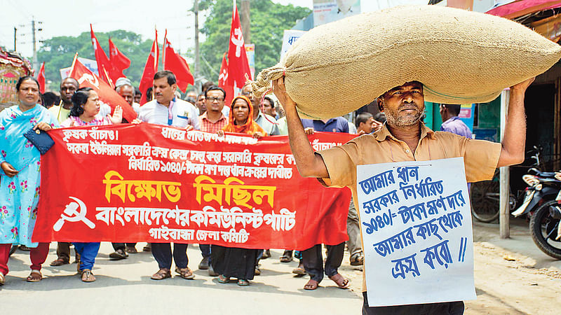 ন্যায্যমূল্যে ধান ক্রয়ের দাবির মিছিলে মাথায় বস্তা নিয়ে অংশ নেন একজন। গতকাল গাইবান্ধা শহরে।  ছবি: প্রথম আলো