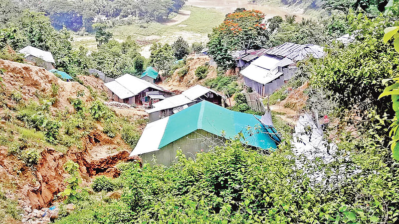 বান্দরবান জেলা শহরের টাঙ্কির পাহাড়ে ঝরনা ও ঝরনার পাড় দখল করে ঝুঁকিপূর্ণ বাসাবাড়ি। গতকাল দুপুরে।  প্রথম আলো