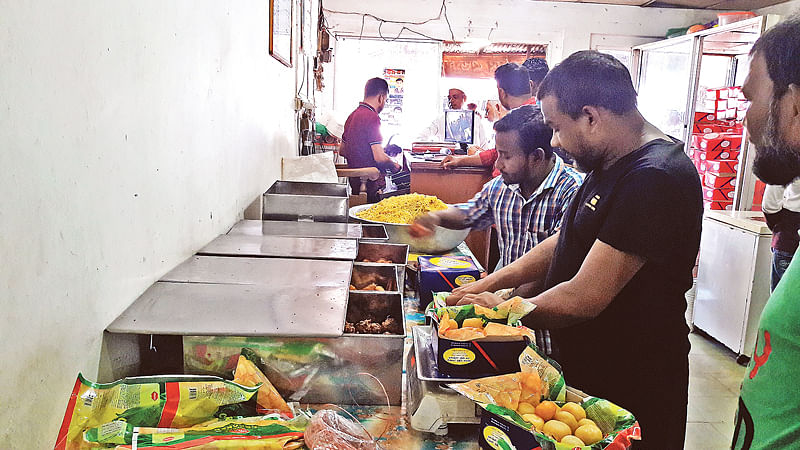 মেয়ের শ্বশুরবাড়ির জন্য ইফতারসামগ্রী বিক্রিতে ব্যস্ত দোকানি ও কর্মচারীরা। সম্প্রতি শমশেরনগর বাজারে।  প্রথম আলো