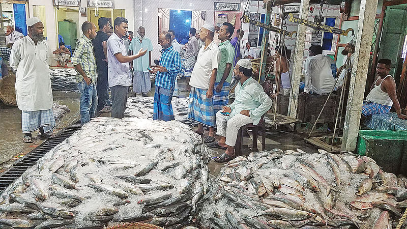 প্রতিদিন কয়েক শ মণ ইলিশ আসছে। এতে ব্যস্ত হয়ে পড়েছেন ইলিশ ব্যবসায়ী ও ঘাটের মৎস্যশ্রমিকেরা। গত সোমবার দুপুরে চাঁদপুর শহরের বড় স্টেশন মাছঘাটের মৎস্য আড়তে।  ছবি: প্রথম আলো