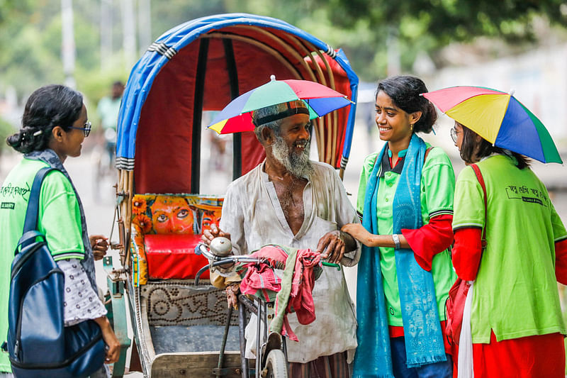 শিক্ষার্থীদের কাছ থেকে ছাতা পেয়ে বেশ খুশি এই রিকশাচালক।