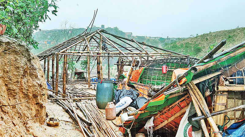 টানা বৃষ্টিতে ভেঙে পড়ে দুটি ঘর। পুনরায় তা মেরামতের চেষ্টা করছে রোহিঙ্গারা। গত মঙ্গলবার উখিয়ার হাকিমপাড়া রোহিঙ্গা শিবিরে।  ছবি: গিয়াস উদ্দিন