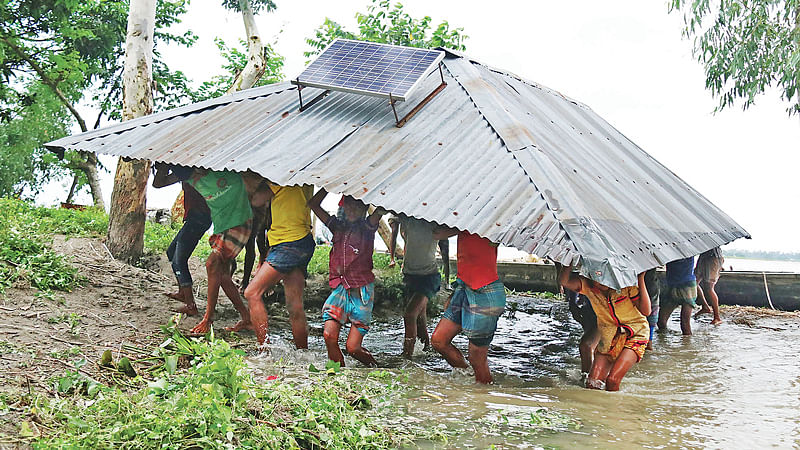 উজান থেকে নেমে আসা ঢলে বন্যায় পানিবন্দী তিস্তা নদী এলাকার মানুষ। এখন আবার শুরু হয়েছে নদীভাঙন। তাই  ঘরবাড়ি ভেঙে নিয়ে যাচ্ছে অন্যত্র। গতকাল রংপুরের কাউনিয়া উপজেলার বালাপাড়া ইউনিয়নের ঢুষমারায়।  ছবি: মঈনুল ইসলাম