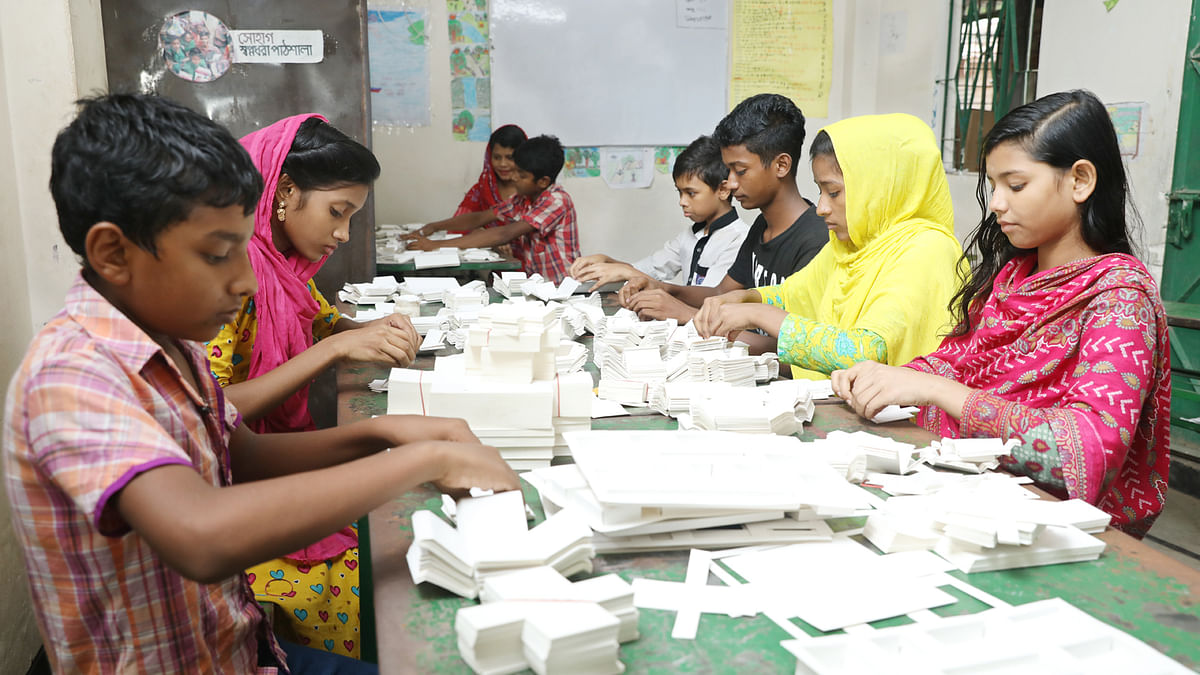 স্কুলের পাঠ শেষে বাক্স তৈরি করছে শিক্ষার্থীরা। এ থেকে আয়ও হয় তাদের। দুয়ারীপাড়া, পল্লবী, ঢাকা, ২৪ জুলাই। ছবি: আবদুস সালাম
