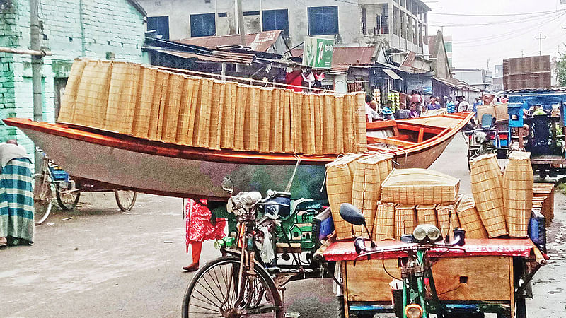 চাঁচকৈড় হাট থেকে মাছ ধরার উপকরণ কিনে নিয়ে যাচ্ছে মানুষ। গতকাল নাটোরের গুরুদাসপুর উপজেলায়।  ছবি: আনিসুর রহমান