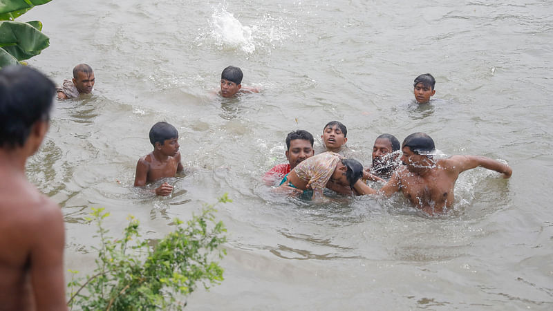 নয় বছরের আয়েশাকে খুঁজতে তুরাগ নদে স্থানীয় লোকজনের তৎপরতা। প্রায় ২০ মিনিট পর আয়েশাকে পানি থেকে উদ্ধার করা হয়। শহীদ সোহরাওয়ার্দী মেডিকেল কলেজ হাসপাতালে নেওয়ার পর চিকিৎসক তাকে মৃত ঘোষণা করেন। ৪ জুলাই, ঢাকা। ছবি: আশরাফুল আলম