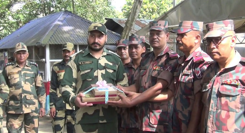 ঈদ উপলক্ষে দিনাজপুরের হিলি সীমান্তে বর্ডার গার্ড বাংলাদেশ (বিজিবি) ও ভারতীয় সীমান্ত রক্ষী বাহিনী (বিএসএফ) একে অপরকে মিষ্টি উপহার দিয়ে ঈদের শুভেচ্ছা বিনিময় করেছে। ছবি: এএসএম আলমগীর