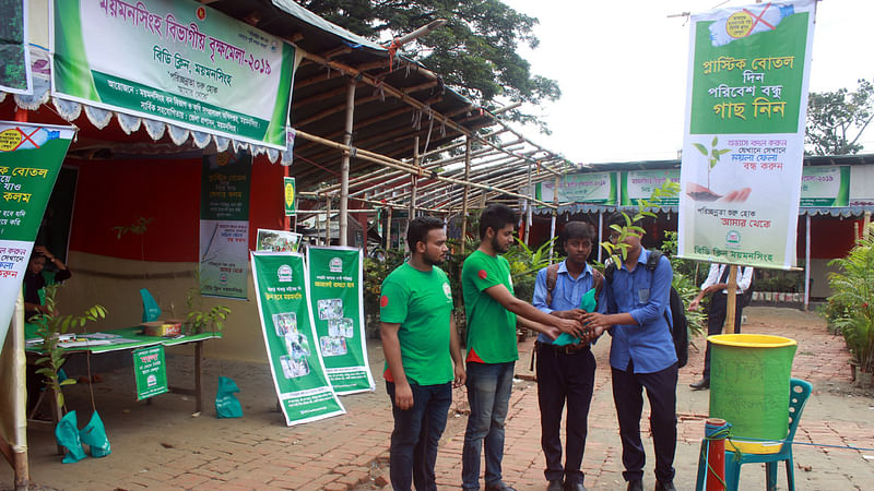 ‘প্লাস্টিক বোতল দিন, পরিবেশ বন্ধু গাছ নিন’—এই স্লোগান নিয়ে বিডি ক্লিন ময়মনসিংহের উদ্যোগে পরিত্যক্ত প্লাস্টিকের বোতলের বদলে গাছের চারা বিতরণ করা হচ্ছে। আজ শনিবার দুপুরে ময়মনসিংহ নগরের টাউন হল প্রাঙ্গণে বিভাগীয় বৃক্ষ মেলায়। ছবি: আনোয়ার হোসেন