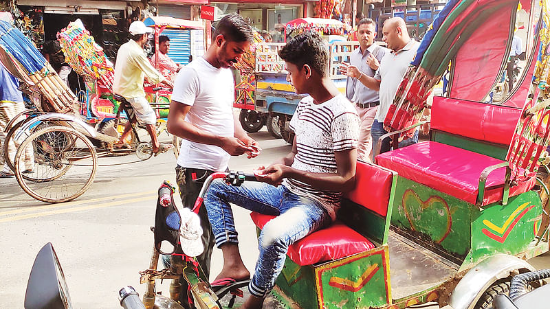 ব্যাটারিচালিত রিকশা থেকে চাঁদা আদায় করছেন এক ব্যক্তি। শনিবার খিলক্ষেতে।  প্রথম আলো