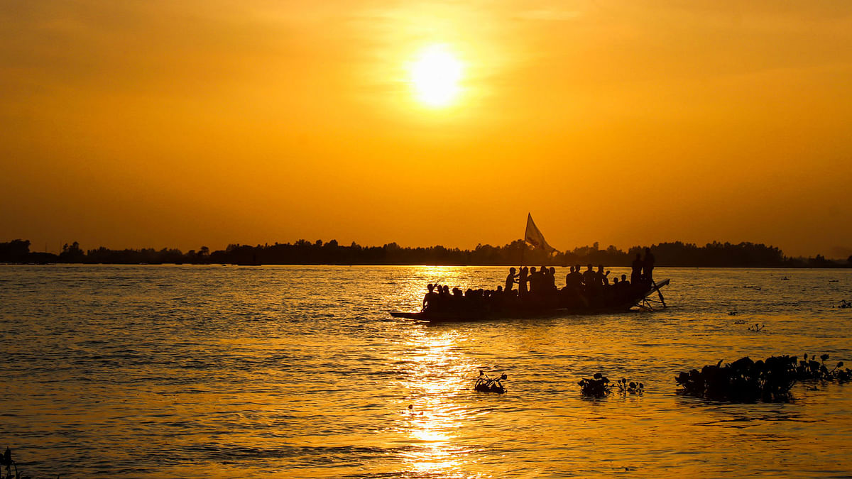 গোধূলিবেলায় নৌকা ভরে ফিরছে মানুষ