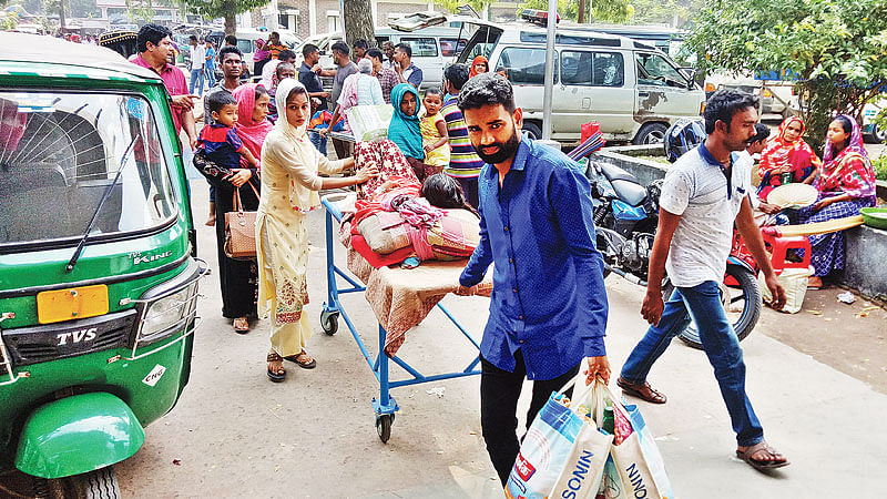 রাজশাহী মেডিকেল কলেজ হাসপাতালে ১০০ টাকা জমা দিয়ে রোগী বহনের জন্য ট্রলি নিচ্ছেন স্বজনেরা। সম্প্রতি রাজশাহী মেডিকেল কলেজ হাসপাতালের জরুরি বিভাগে।  প্রথম আলো