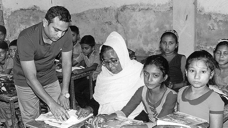 ঝিনাইদহের হরিণাকুণ্ডু উপজেলা সদরের বাসিন্দা রুসিয়া বেগমকে পড়া বুঝিয়ে দিচ্ছেন এক শিক্ষক।  সম্প্রতি তোলা ছবি।  প্রথম আলো