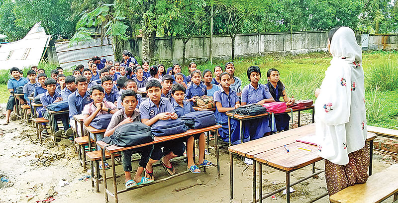 খোলা জায়গায় চলছে পাঠদান। গতকাল সকালে নারায়ণগঞ্জের রূপগঞ্জের হাটাব সরকারি প্রাথমিক বিদ্যালয়ে।  ছবি: প্রথম আলো