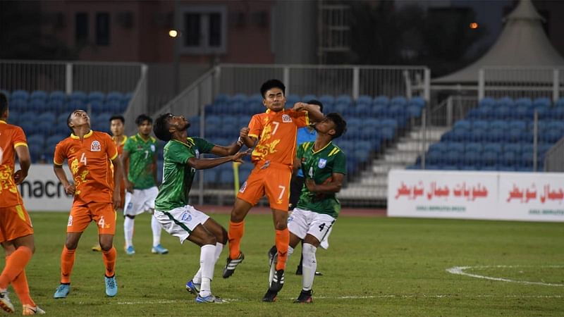 বল দখলের লড়াইয়ে বাংলাদেশ ও ভুটানের ফুটবলাররা। ছবি: বাফুফে