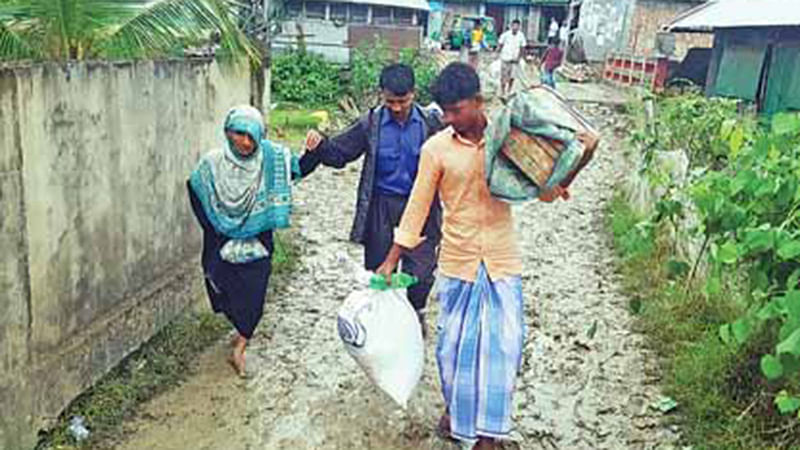 ব্যাগ-বোঁচকা নিয়ে আশ্রয়কেন্দ্রে ছুটছেন মানুষ। গতকাল বিকেলে চট্টগ্রামের বাঁশখালীর খানখানাবাদ ইউনিয়নের উপকূলীয় এলাকা প্রেমাশিয়ায়।  ছবি: প্রথম আলো