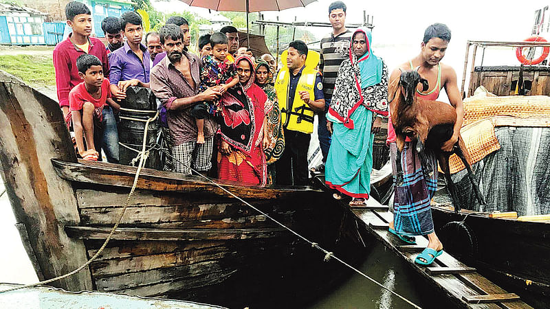 পটুয়াখালীর রাঙ্গাবালীর  চর গঙ্গায় বাঁধ ও আশ্রয়কেন্দ্র নেই। তাই ওই চরের বাসিন্দাদের ট্রলারে আশ্রয়কেন্দ্রে নিয়ে আসা হচ্ছে।  ছবি: প্রথম আলো