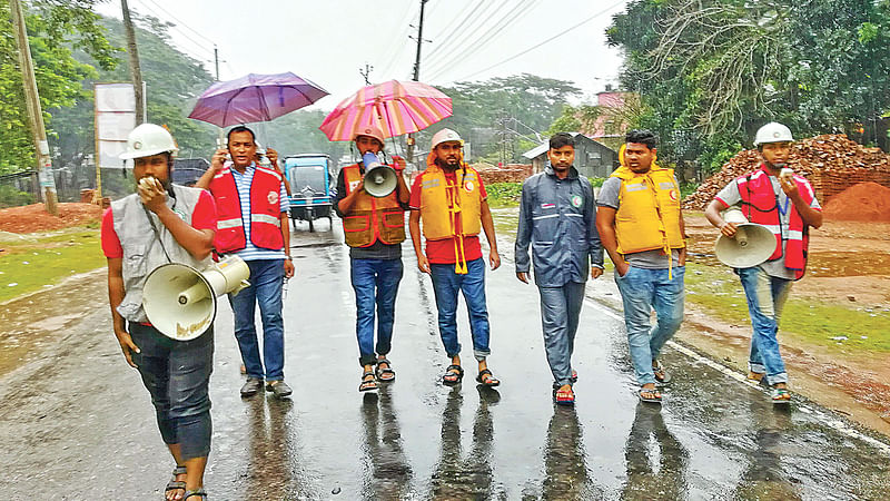 ঘূর্ণিঝড়ের বিষয়ে মানুষকে সতর্ক করার পাশাপাশি আশ্রয়কেন্দ্রে যাওয়ার জন্য মাইকিং করছেন স্বেচ্ছাসেবকেরা। গতকাল দুপুরে পিরোজপুর সদরের হুলারহাট সড়কে।  ছবি: প্রথম আলো