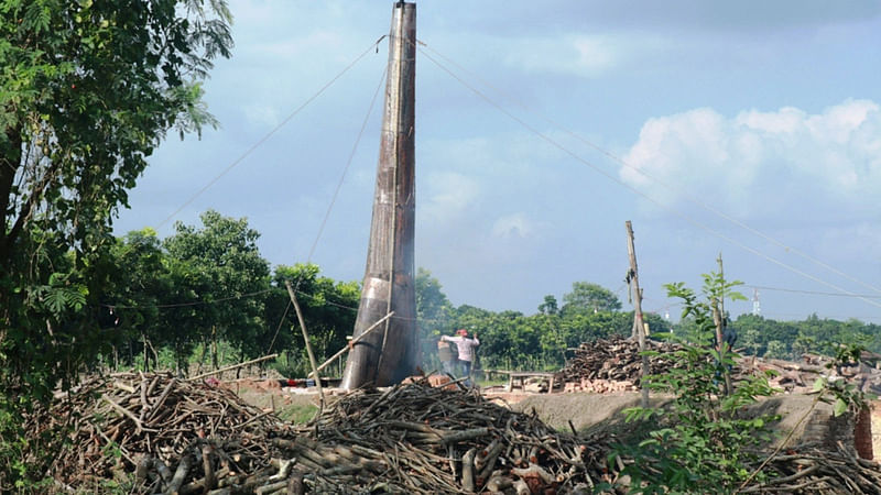 কাঠ দিয়ে ইট পোড়াতে স্থাপন করা হচ্ছে টিনের চিমনি। শ্রীকুন্ডি, মাগুরা সদর, ১১ নভেম্বর। ছবি: কাজী আশিক রহমান