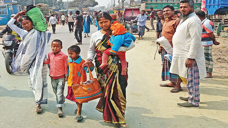 বাস না পেয়ে বিভিন্ন গন্তব্যের যাত্রীরা বিপাকে পড়েন। অন্য যানবাহনের খোঁজে জয়ন্তী রানী ও তাঁর পরিবার। গতকাল সকালে ঠাকুরগাঁও পুরোনো বাসস্ট্যান্ড এলাকায়।  ছবি: প্রথম আলো