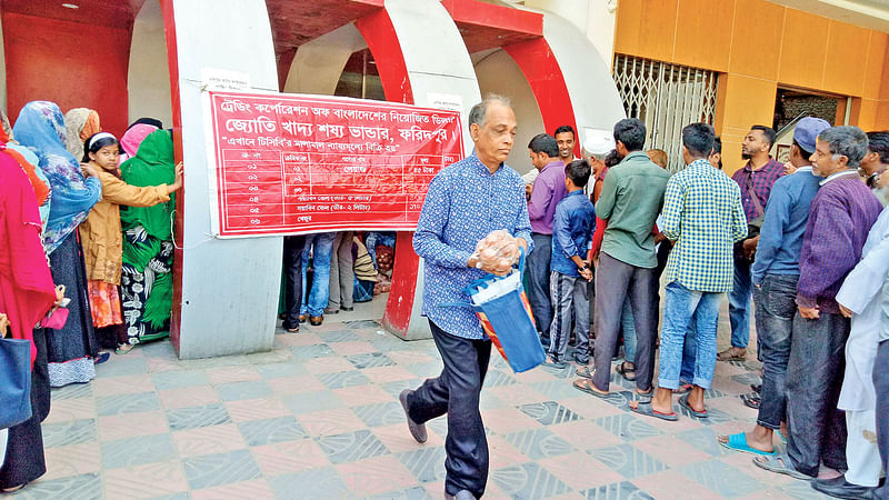 বাজারে পেঁয়াজের দাম চড়া। তাই টিসিবির ৪৫ টাকা কেজি দরের পেঁয়াজ কিনতে ভিড় করেছে মানুষ। গতকাল সকালে ফরিদপুর জেলা প্রশাসকের কার্যালয় চত্বরে।  ছবি: প্রথম আলো