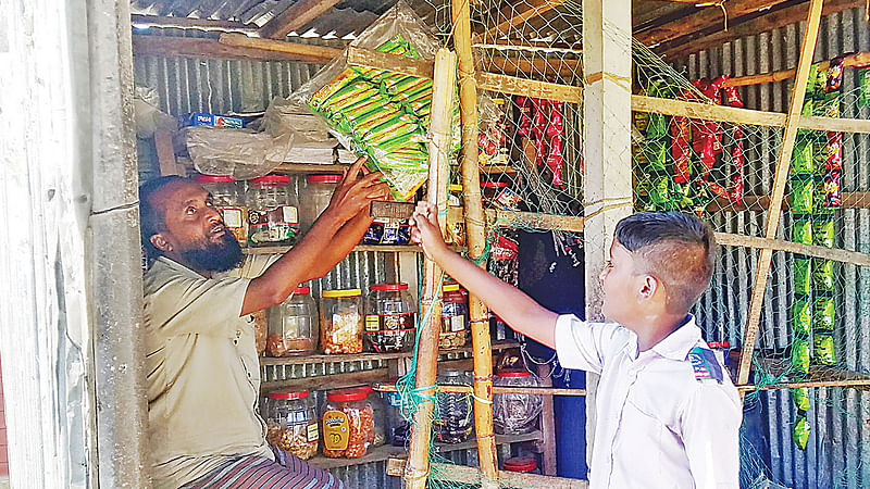 গাজীপুর সরকারি প্রাথমিক বিদ্যালয়ে খাইরুলের দোকানে কেনাকাটা করছে এক শিশু।  প্রথম আলো