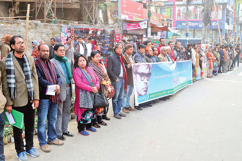 ঋত্বিক ঘটকের পৈতৃক ভিটা দখলমুক্ত করে সরকারি হেরিটেজ ঘোষণার দাবিতে মানববন্ধন করে কয়েকটি সাংস্কৃতিক সংগঠন। গতকাল রাজশাহী নগরের সাহেববাজার জিরো পয়েন্টে।  ছবি: প্রথম আলো