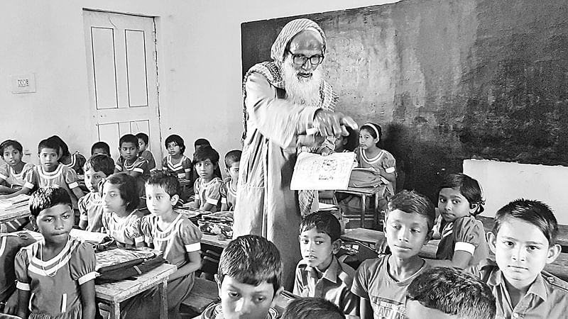 অবসরের পরও পাঠদান করান আবদুর রহমান। সম্প্রতি গুরুদাসপুরের খুবজীপুর সরকারি প্রাথমিক বিদ্যালয়ে।  ছবি: প্রথম আলো