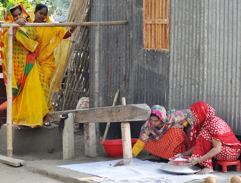 পিঠার জন্য ঢেঁকিতে আতপ চাল কোটা হচ্ছে