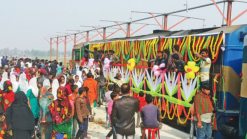 পাবনার বেড়া উপজেলায় চালু হওয়া রেলপথে নতুন ট্রেন দেখতে ভিড় জমান স্থানীয়রা। গতকাল বেড়ার ঢালারচর স্টেশনে। প্রথম আলো