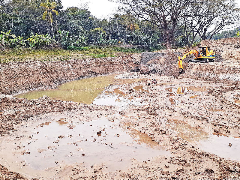 ফরিদপুর পৌরসভার সাদীপুর সেতু সংলগ্ন মান্দারতলা খালের পশ্চিম পাশে ভাজনডাঙ্গা এলাকায় সরকারি হালটের জমির উপরিভাগের মাটি কেটে বিক্রি করে দেওয়া হয়েছে। গতকাল তোলা ছবি।  প্রথম আলো