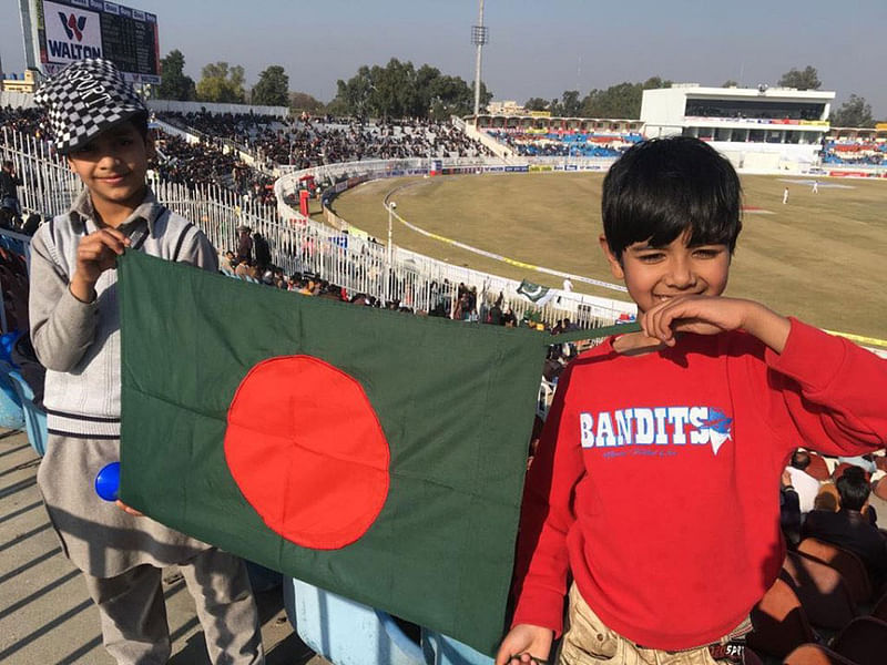 কাল রাওয়ালপিন্ডি স্টেডিয়ামে বাংলাদেশের পতাকা। সাদমানের সঙ্গে বাঁ পাশের ছেলেটা পাকিস্তানি। ছবি: রানা আব্বাস