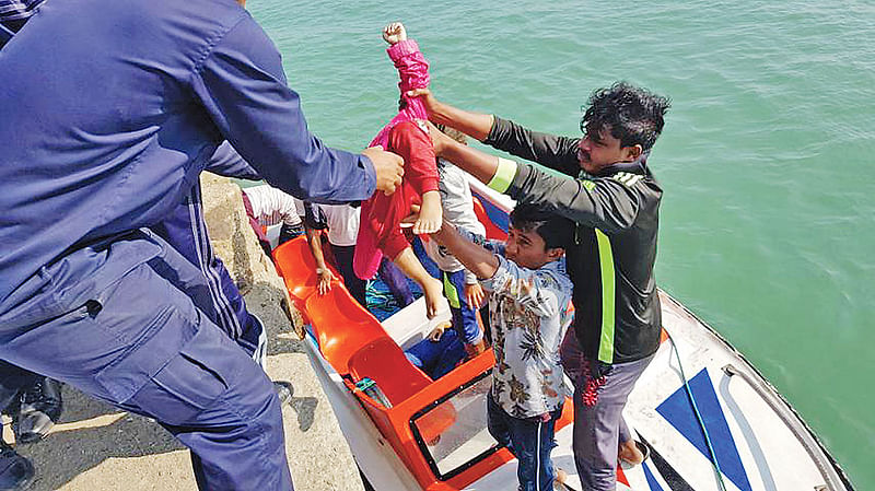 সমুদ্রপথে অবৈধভাবে মালয়েশিয়ায় যাওয়ার পথে সেন্ট মার্টিন দ্বীপের পশ্চিমে বঙ্গোপসাগরে ট্রলারডুবির ঘটনায় এক শিশুর লাশ উদ্ধার করছেন কোস্টগার্ডের সদস্যরা। গতকাল দুপুরে  সেন্ট মার্টিন জেটিঘাটে। ছবি: প্রথম আলো