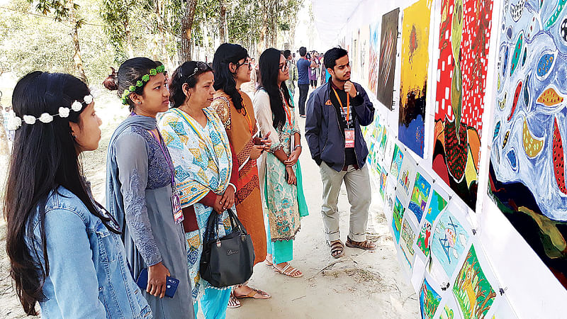 আন্তর্জাতিক চারুকলা উৎসব-২০২০–এর সমাপনী দিনে দেশ–বিদেশের শিল্পীদের আঁকা ছবির প্রদর্শনী দেখছেন দর্শনার্থীরা। গতকাল নীলফামারীর নীলসাগরে।  ছবি: প্রথম আলো