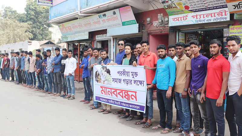 পরকীয়ার বিরুদ্ধে সচেতনতা গড়ে তুলতে নাটোরের গুরুদাসপুরে মানববন্ধন কর্মসূচি পালন করেন একদল তরুণ। আজ বুধবার বেলা ১১টার দিকে পৌর শহরের চাঁচকৈড় বাজার এলাকা থেকে তোলা ছবি। ছবি: সংগৃহীত