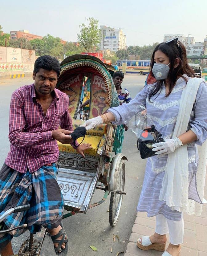 বেলা দুইটা থেকে বিকেল চারটা পর্যন্ত এই শিল্পী তাঁর ছোট ভাইকে সঙ্গে নিয়ে প্রায় সাত শ মাস্ক বিতরণ করেন। ছবি: প্রথম আলো