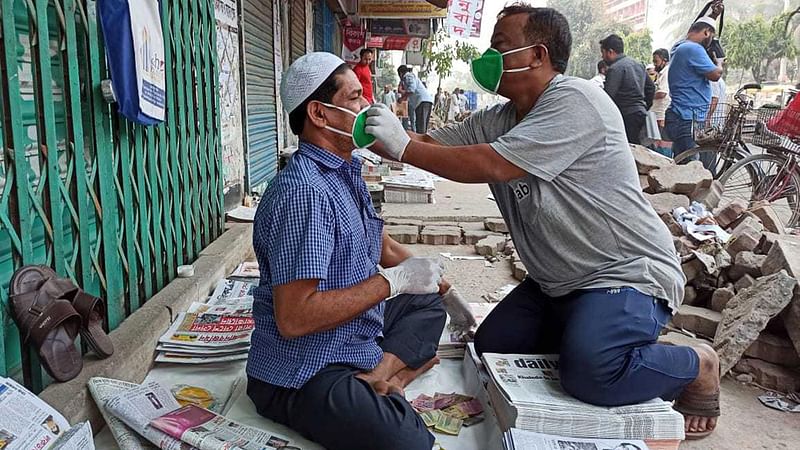 করোনা সংক্রমণের প্রেক্ষাপটে নিরাপদ থেকে হকাররা যাতে পত্রিকা বিলি করতে পারেন, সে জন্য নোয়াবের পক্ষ থেকে মাস্ক ও গ্লাভস বিতরণ করা হয়। বুধবার রাজধানীর মতিঝিলে। ছবি: প্রথম আলো