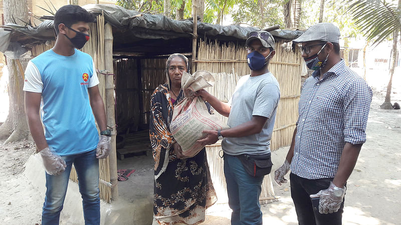 বাড়ি বাড়ি গিয়ে শ্রমজীবী মানুষের হাতে খাদ্যসামগ্রী তুলে দিচ্ছেন বিশ্ববিদ্যালয়পড়ুয়া শিক্ষার্থীরা। কুন্দশী গ্রাম, লোহাগড়া, নড়াইল, ৩০ মার্চ। ছবি: প্রথম আলো