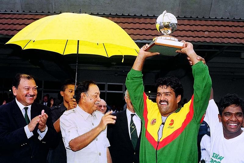 ১৯৯৭ আইসিসি ট্রফি জয়ের পর মালয়েশিয়ার রাজার হাত থেকে নিচ্ছেন অধিনায়ক আকরাম খান। সঙ্গে আমিনুল ইসলাম।