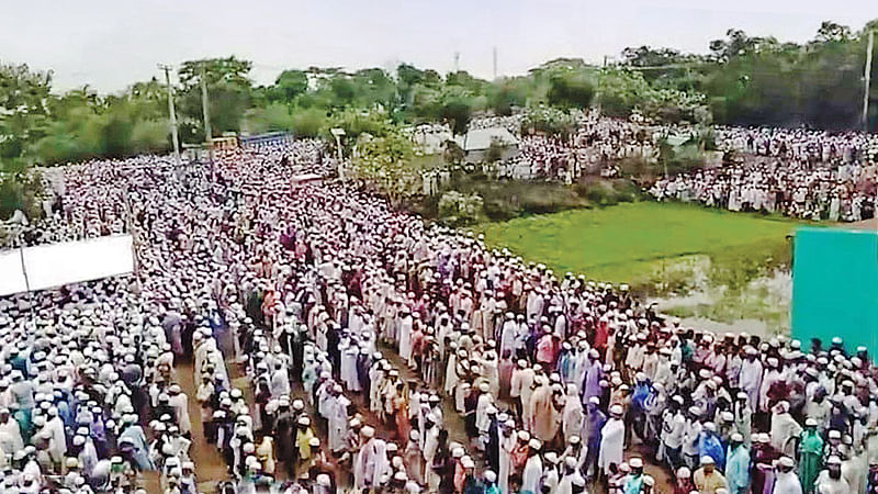 করোনাভাইরাসের সংক্রমণ ঠেকাতে সারা দেশে এখন জনসমাগম নিষিদ্ধ। নামাজও মসজিদে না গিয়ে ঘরে আদায় করার পরামর্শ দিয়েছে ইসলামিক ফাউন্ডেশন। এ নিয়ম মানা হচ্ছে সৌদি আরবসহ বিভিন্ন মুসলিম দেশে, এমনকি বাংলাদেশেও। অথচ খেলাফত মজলিসের নায়েবে আমির মাওলানা যোবায়ের আহমদ আনসারীর জানাজায় সামাজিক দূরত্বের নির্দেশনা মানা হয়নি। লকডাউন সত্ত্বেও হাজারো মানুষ জানাজায় অংশ নেন। গতকাল ব্রাহ্মণবাড়িয়ার সরাইলে জামিয়া রহমানিয়া বেড়তলা মাদ্রাসামাঠে। ছবি: প্রথম আলো