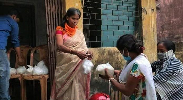 নিজের বাড়ি থেকে ত্রাণ দিচ্ছেন রানু মণ্ডল। ছবি: সংগৃহীত