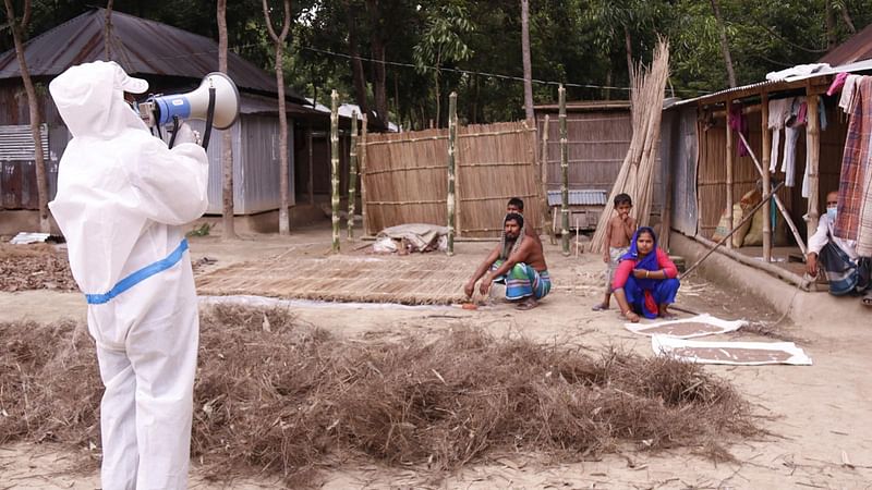 করোনাভাইরাস বিষয়ে প্রচারণায় ব্যস্ত জকির হোসেন। বুধবার দুপুরে ফরিদপুর সদরের কৃষ্ণনগর ইউনিয়নের মণ্ডলপাড়া গ্রামে। ছবি: প্রথম আলো