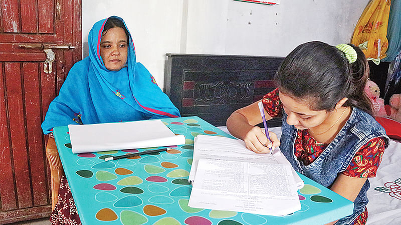 রাজশাহীতে শিক্ষক ফারুক হোসেনের ব্যক্তিগত উদ্যোগে শিক্ষার্থীরা নিজ বাড়িতে পরীক্ষা দিচ্ছে। গতকাল বেলা ১১টার দিকে নগরের ভাটাপাড়া এলাকার এক বাড়িতে।  ছবি: প্রথম আলো