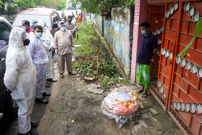 করোনা রোগীদের বাড়িতে বাড়িতে খাদ্যসহায়তা নিয়ে হাজির কুষ্টিয়ার জেলা প্রশাসক আসলাম হোসেন। গতকাল শুক্রবার বিকেলে শহরের পেয়াতলাতলা এলাকায়। ছবি: প্রথম আলো